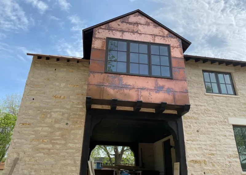 Copper metal panel facade on a stone building for Roof Repair in Garnet
